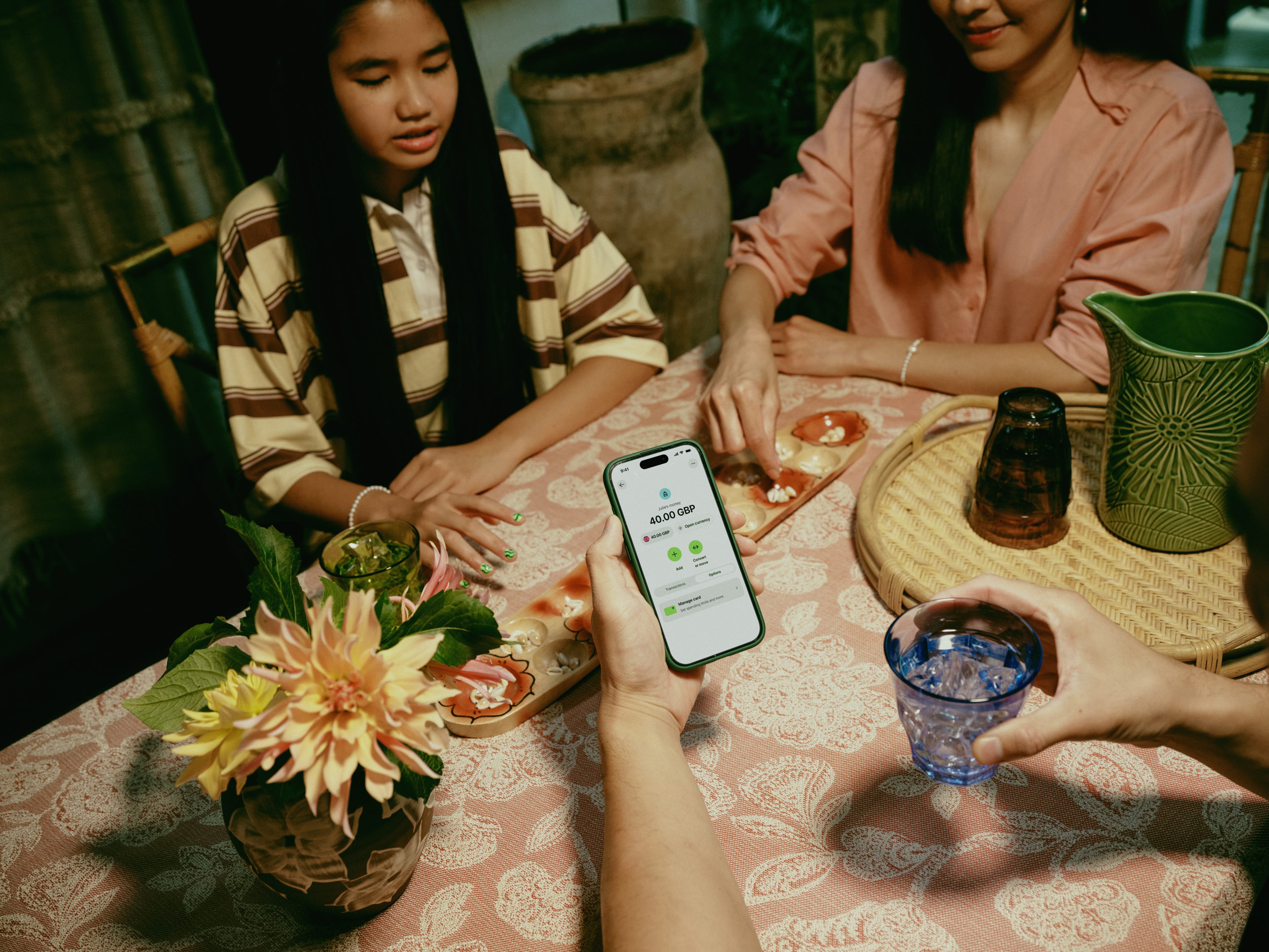 person holding a phone at a dinner table
